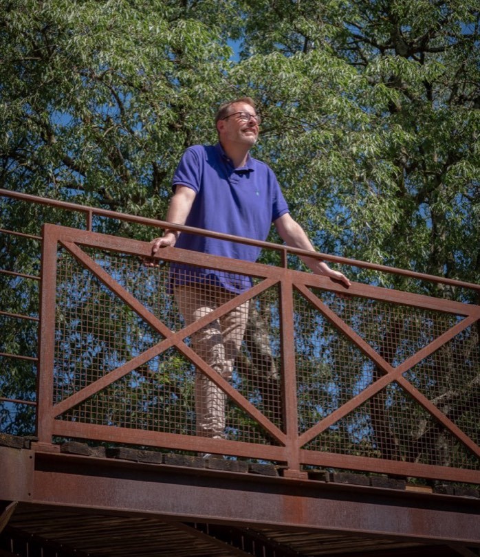 Emmanuel Hervé en extérieur, sur une passerelle dans la nature